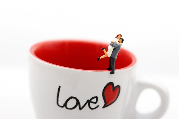 Miniature people Couple Lover standing on cup off coffee, lovely concept.