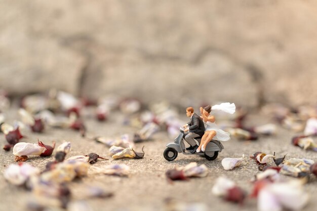 Miniature people Couple riding the motorcycle in the garden