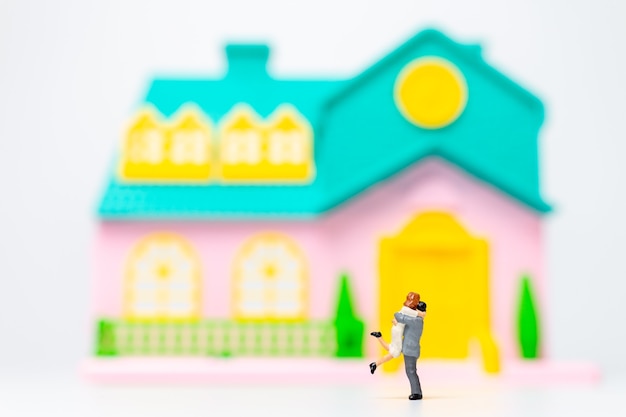 Miniature people , Couple standing together in front of their house