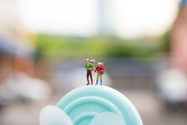 Miniature people, couple traveler standing on turbine using as adventure concept