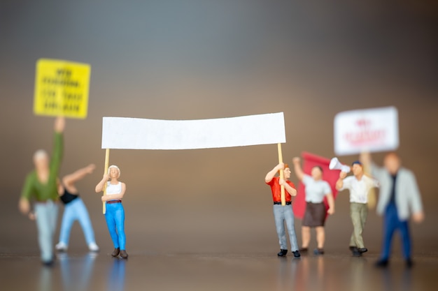 Foto persone in miniatura, folla di manifestanti persone hanno alzato le mani e gridando