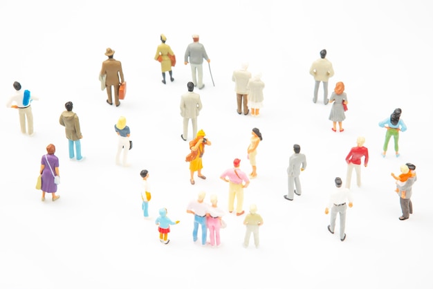 Foto persone in miniatura persone diverse stanno su uno sfondo bianco le persone comunicano tra loro comunicazione della società di diverse generazioni