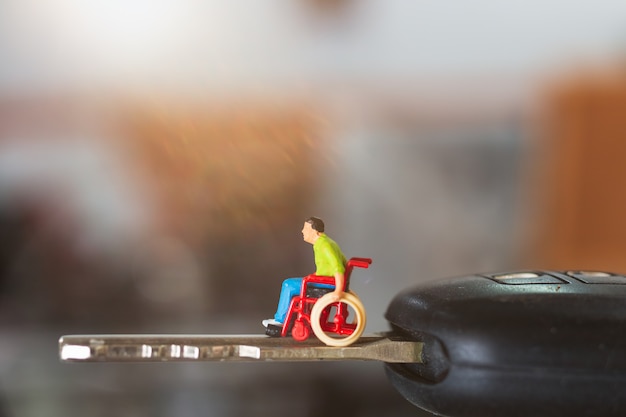 Foto persone disabili in miniatura uomo seduto in sedia a rotelle