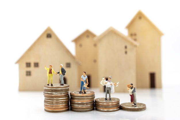 Persone in miniatura: persona anziana in piedi su una pila di monete con casa, concetto di pianificazione della pensione.