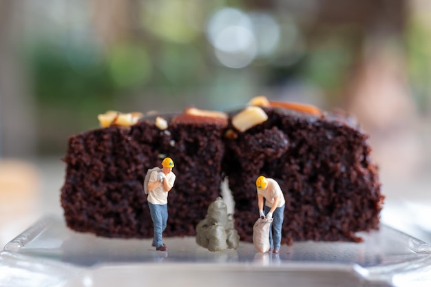 Photo miniature people an employee is making a chocolate brownie