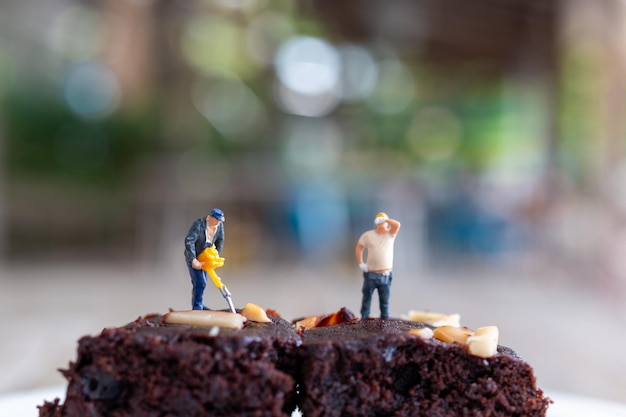 Miniature people An employee is making a chocolate brownie