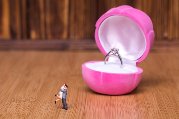 Miniature people and an engagement ring Creative concept about the proposal