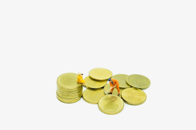 Miniature people engineer working and woman watching on coins