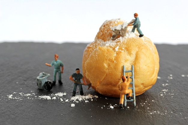 miniature people filling the cream puffs