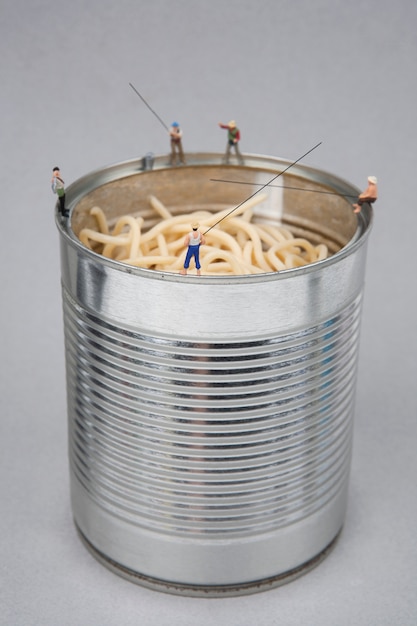 Miniature people fishing on cans