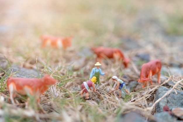 Miniature people: Gardener working on The field