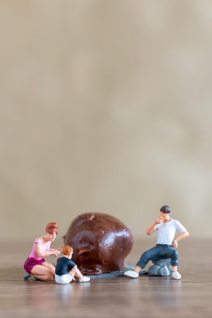 Miniature people Happy family enjoying chocolate