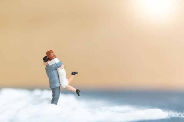 Miniature people Happy wedding couple on white beach , wedding concept