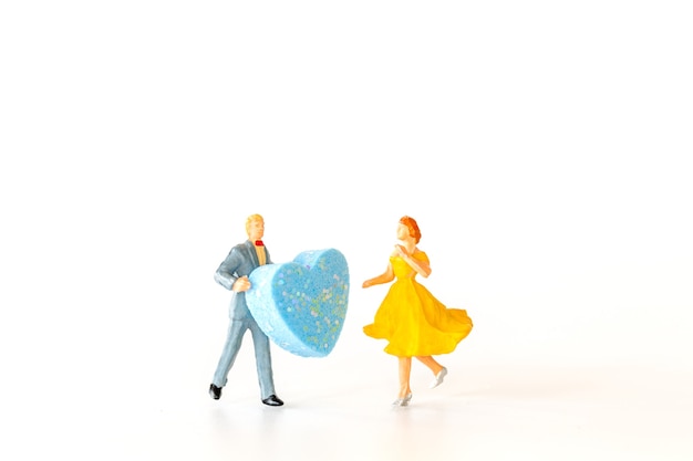 Miniature people , Man giving to his woman a big heart ,