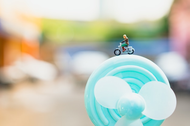 Miniature people, man riding on turbine using for tourism concept