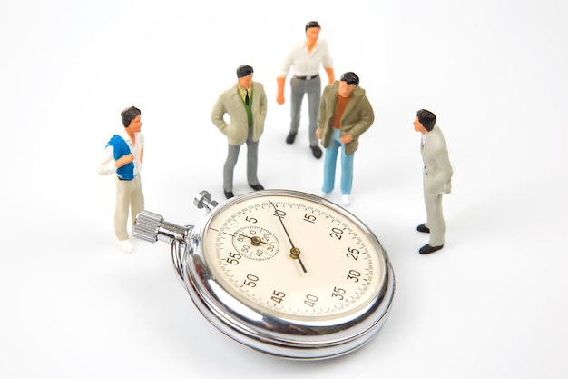 Miniature people mechanical stopwatch on the background of business people Part time accuracy for business business and finance time