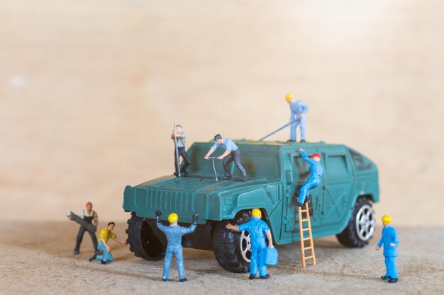Miniature people mechanics fix A military vehicle ,  Car service concept