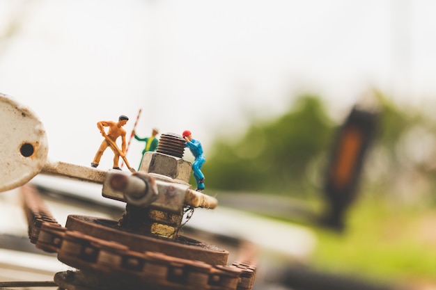 Miniature people : mechanics repairing bicycle 