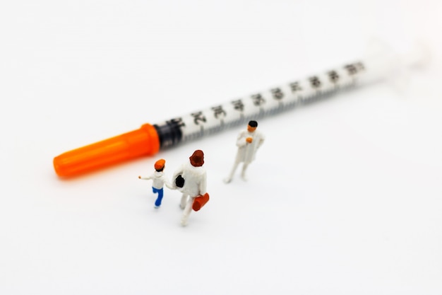 Miniature people, Mother and children meet doctor with syringe 