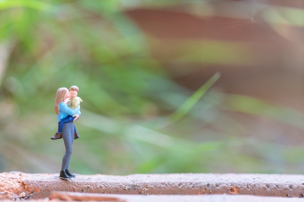 Foto madre di persone in miniatura che tiene il suo bambino sveglio, concetto di giorno di madri felice