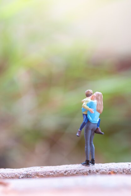 Photo miniature people mother holding her cute baby ,happy mothers day concept