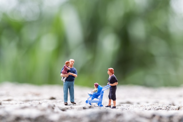 Miniature people:  Parents with children walking outdoor