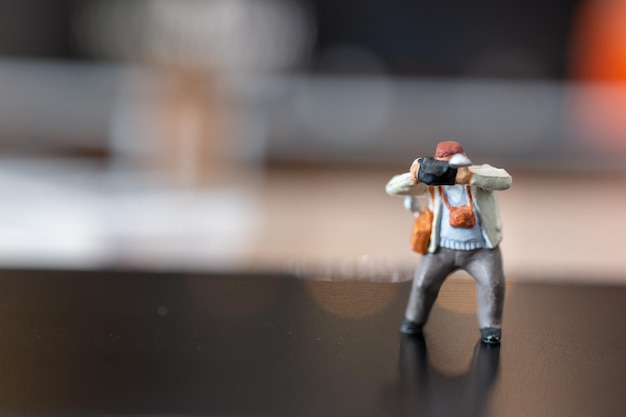 Foto fotografia di persone in miniatura che tiene una macchina fotografica e copia lo spazio per il testo