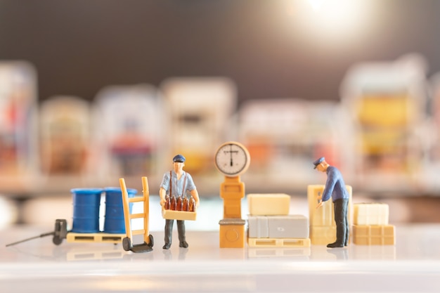 Miniature  people postman officer on duty, he prepares to send a box to consumer. delivery service for ecommerce concept