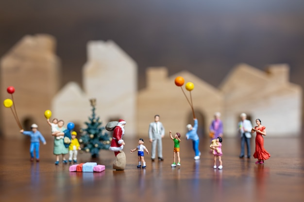 Miniature people: Santa Claus and happy family  