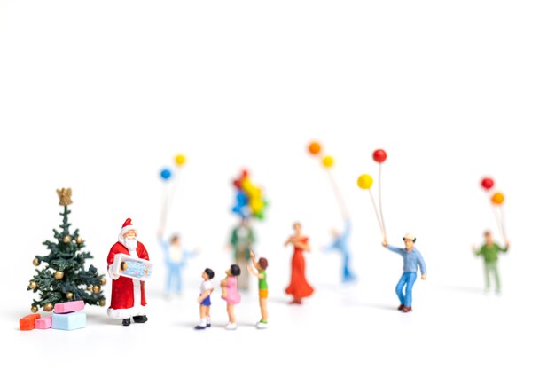 Miniature people : Santa Claus holding gift for happy family