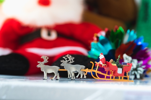 Miniature people, Santa Claus on raindeer vehicle using as Christmas and New Year holiday concept