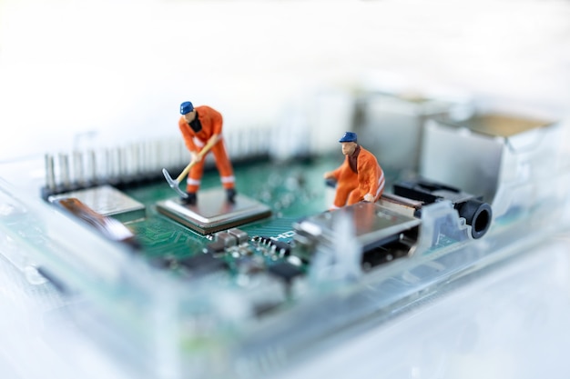 Miniature people searching or checking for bugs and issue on microchip, mainboard of computer.