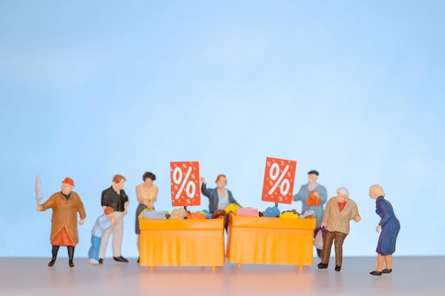 Miniature people , Shoppers with discount tray for shopping discounted items