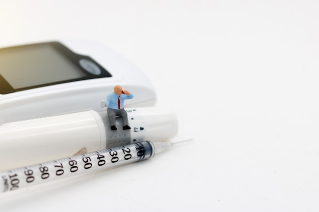 Photo miniature people sitting on glucose meter