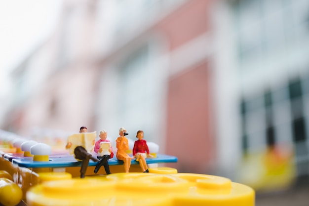Gente miniatura che si siede sul mini xilofono usando come concetto sociale e di riunione d'affari