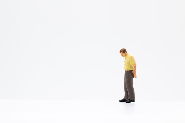 Miniature people standing on white background