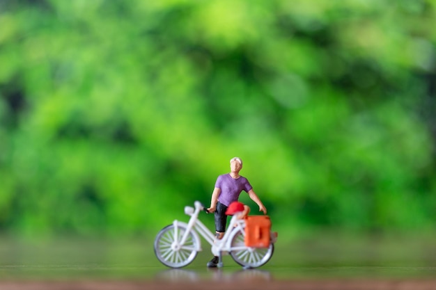 Miniature people standing with bike World bicycle day concept