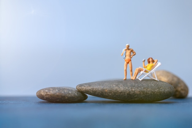 Miniature people sunbathing on The beach , Summer time concept