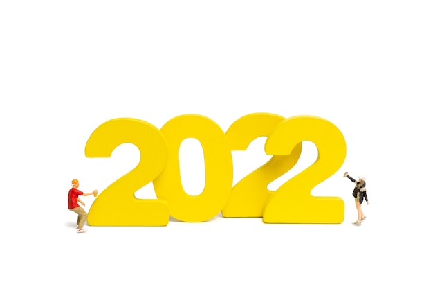 Miniature people Teenager spraying paint Number 2022 on white background , Happy new year concept