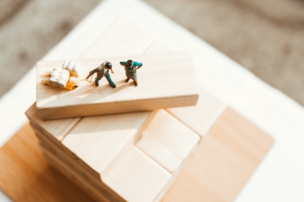 Miniature people, top view of man standing on work site, using for logistic and business concept - V