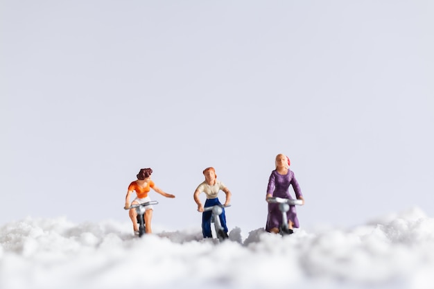 Photo miniature people : travelers riding a bicycle on snow