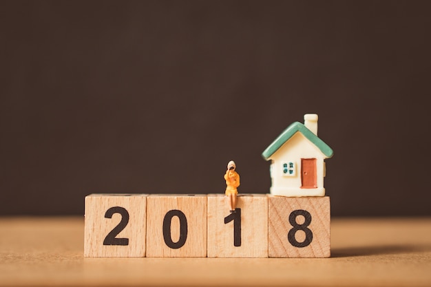 Miniature people, woman sitting on wooden number block year 2018 - Vintage filter