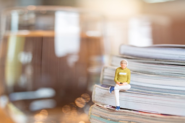 Miniature people Woman wearing headphones and listening to music on smartphone