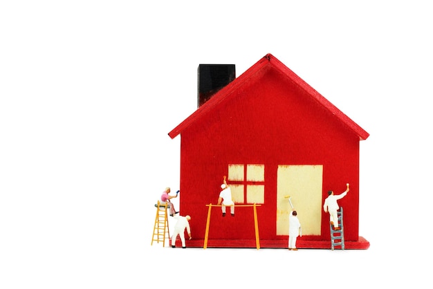 miniature people work as painter wooden housel with paint tools on white background