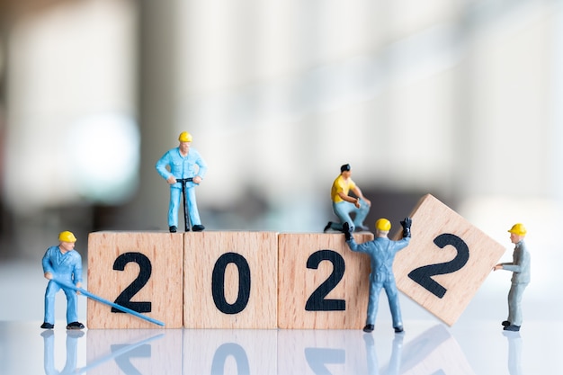 Miniature people : Worker team create wooden block number 2022 , Happy new year concept