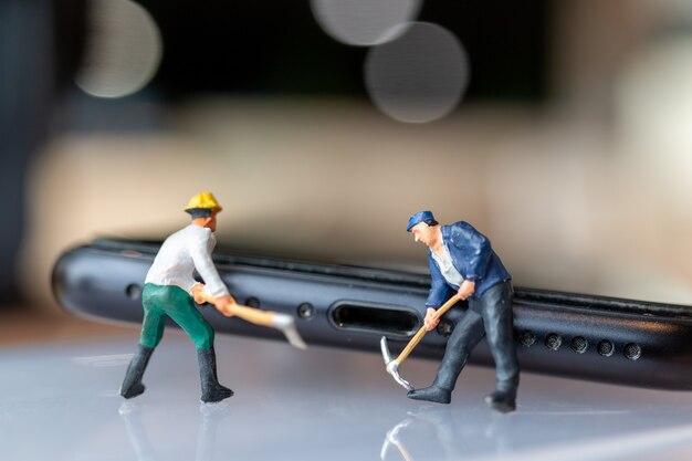 Miniature people Worker with tools repairing mobile phone, Electronic Devices Concept