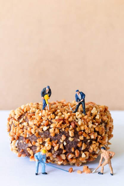 Miniature people working team making homemade chocolates butternut donuts