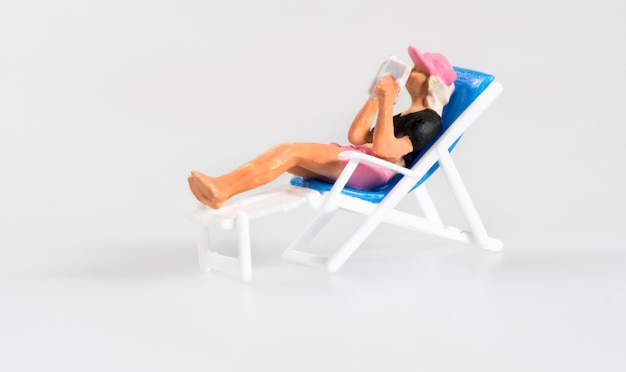 Miniature person relaxing on a deckchair