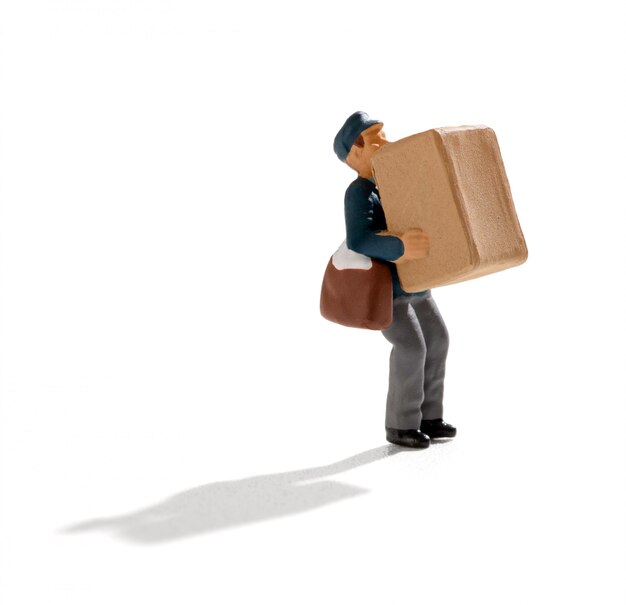 Photo miniature postman carrying a large brown box