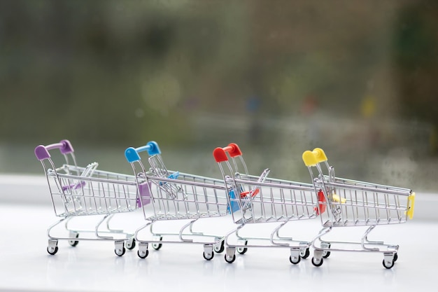 Miniature shopping cart on wooden mock up over blurred green garden on day noon light Image for Shopping online concept